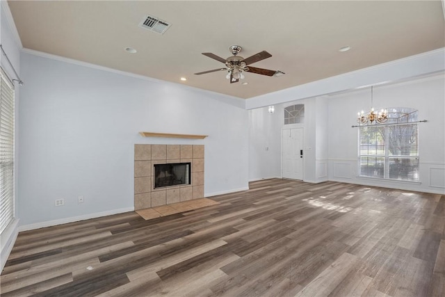 unfurnished living room featuring a fireplace, ceiling fan with notable chandelier, dark hardwood / wood-style floors, and ornamental molding