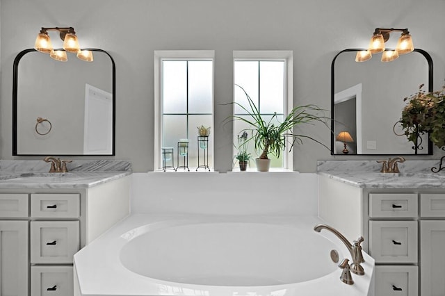 bathroom featuring vanity, tiled bath, and a chandelier