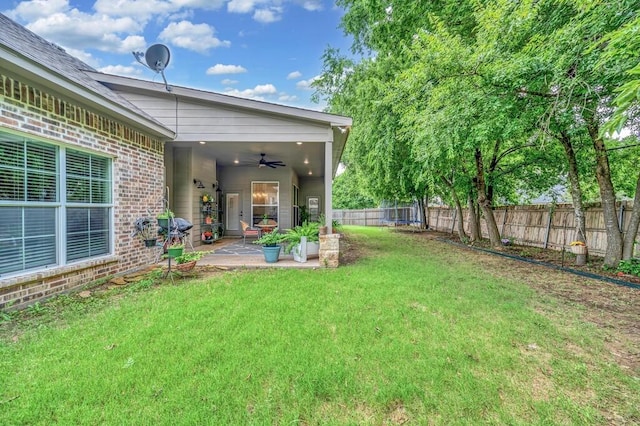 view of yard featuring a patio area and ceiling fan