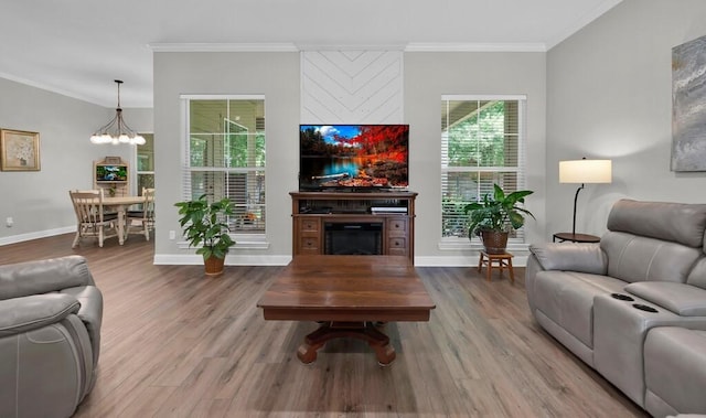 living room featuring hardwood / wood-style flooring, a chandelier, and ornamental molding