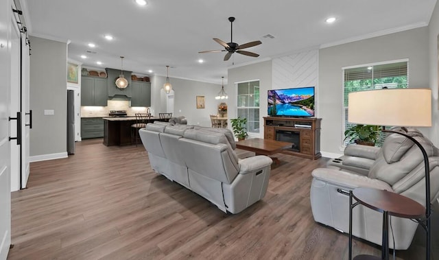 living room featuring hardwood / wood-style floors, ceiling fan, and ornamental molding