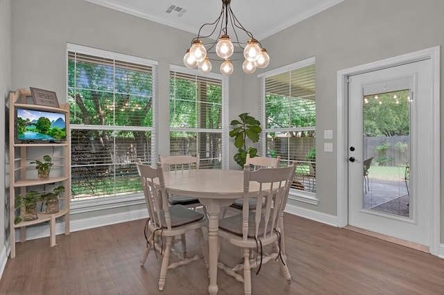 dining area with dark hardwood / wood-style flooring, a wealth of natural light, and a chandelier