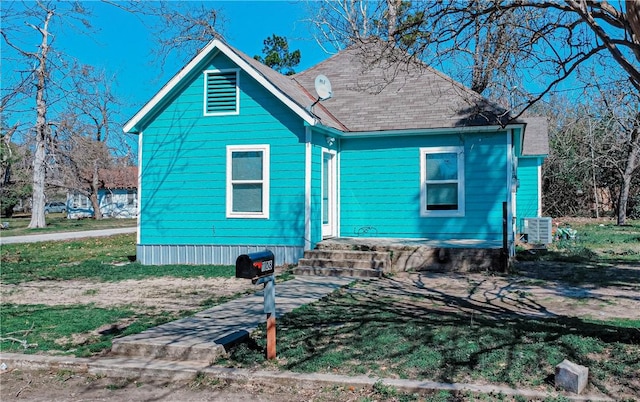 exterior space featuring central AC unit and roof with shingles