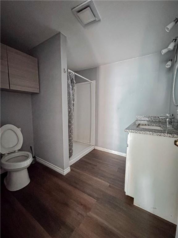 bathroom with curtained shower, visible vents, vanity, wood finished floors, and baseboards