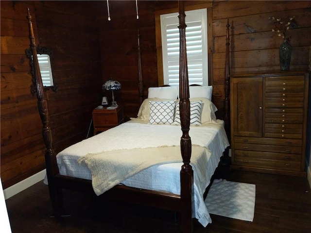 bedroom featuring wooden walls and dark hardwood / wood-style flooring