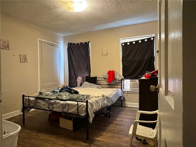 bedroom featuring a textured ceiling, dark hardwood / wood-style flooring, and cooling unit