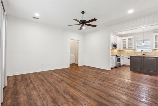 unfurnished living room with ceiling fan, sink, dark wood-type flooring, and ornamental molding