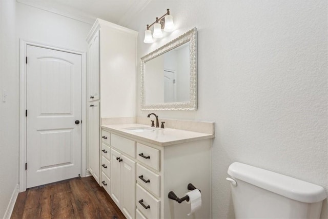 bathroom with vanity, hardwood / wood-style flooring, toilet, and ornamental molding