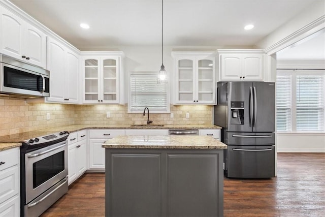 kitchen with hanging light fixtures, a center island, sink, and appliances with stainless steel finishes