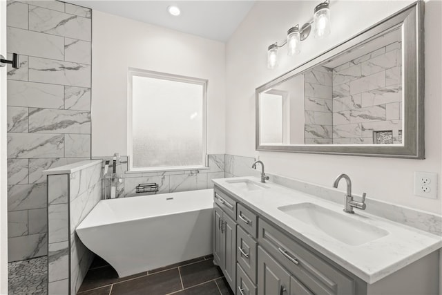 bathroom featuring tile patterned flooring, a bathtub, tile walls, and vanity