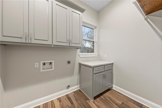 washroom with hookup for an electric dryer, hookup for a washing machine, dark hardwood / wood-style floors, and cabinets