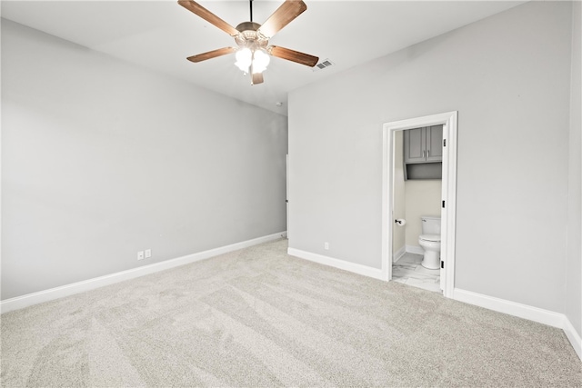 unfurnished bedroom with light carpet, ensuite bathroom, a walk in closet, ceiling fan, and a closet