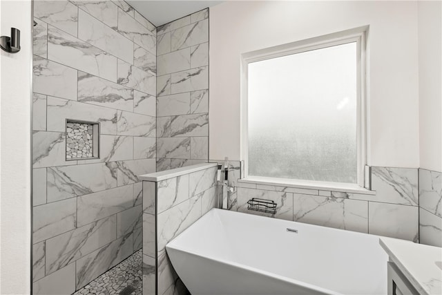 bathroom with a healthy amount of sunlight, tile walls, and separate shower and tub