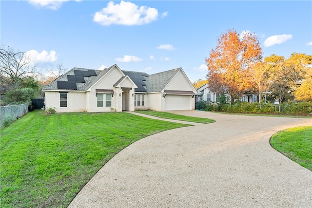 view of front of house with solar panels, a garage, and a front lawn