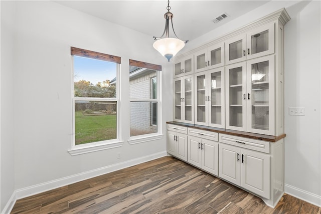 unfurnished dining area featuring dark hardwood / wood-style floors