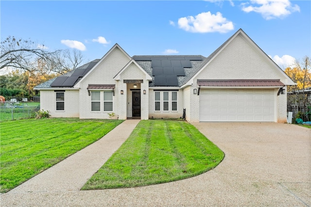 view of front of home with a front yard, solar panels, and a garage