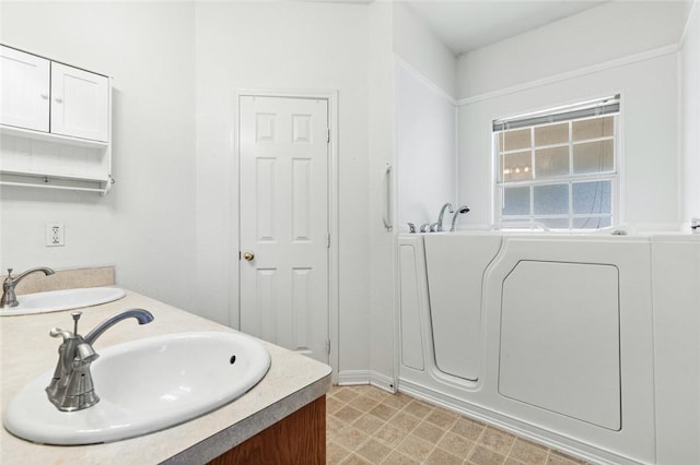 bathroom featuring vanity, a bathtub, and washer / dryer