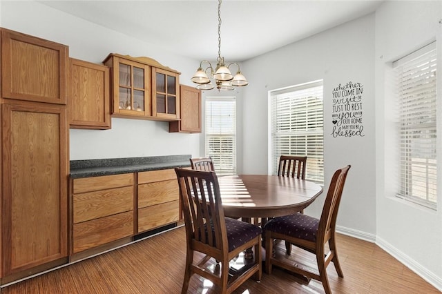 dining area featuring wood-type flooring, a wealth of natural light, and a chandelier