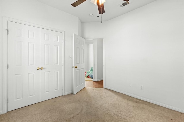 unfurnished bedroom with light carpet, a closet, and ceiling fan