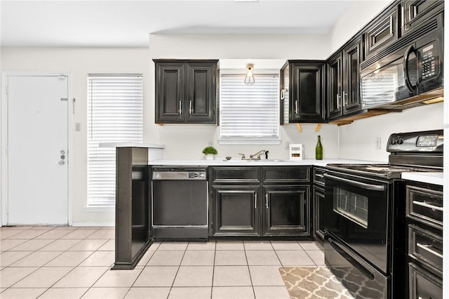 kitchen featuring black appliances, light tile patterned floors, and sink