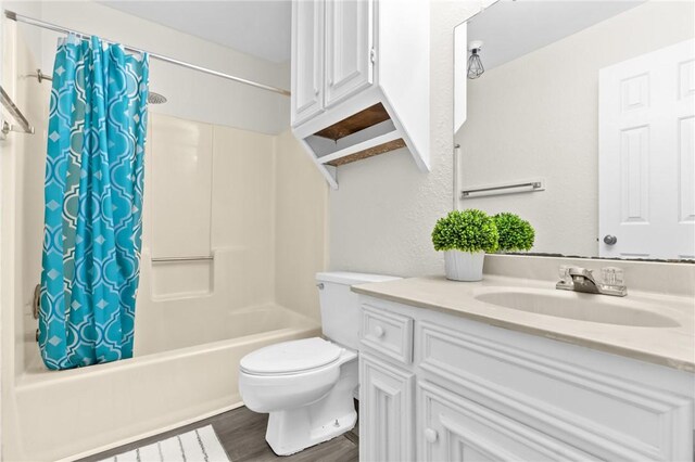 full bathroom with shower / tub combo, vanity, hardwood / wood-style flooring, and toilet