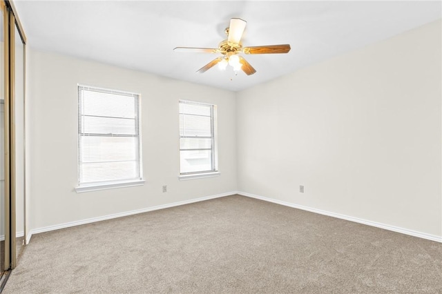 carpeted spare room featuring ceiling fan