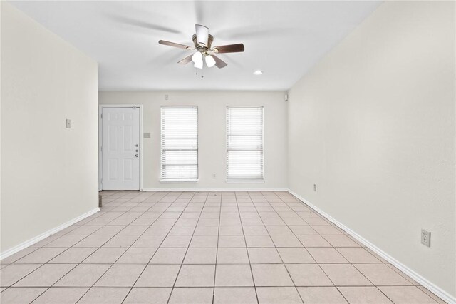 empty room with ceiling fan and light tile patterned floors