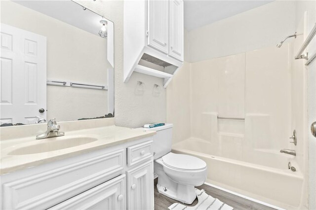 full bathroom with shower / bathing tub combination, wood-type flooring, vanity, and toilet