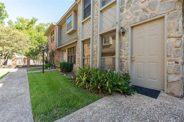 view of exterior entry featuring a yard