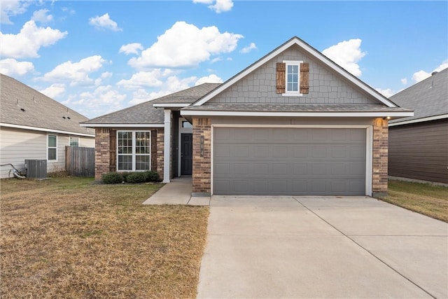 view of front of house featuring a front lawn, a garage, and cooling unit