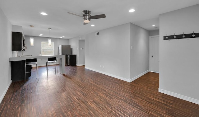 interior space featuring recessed lighting, dark cabinets, dark wood finished floors, and light countertops