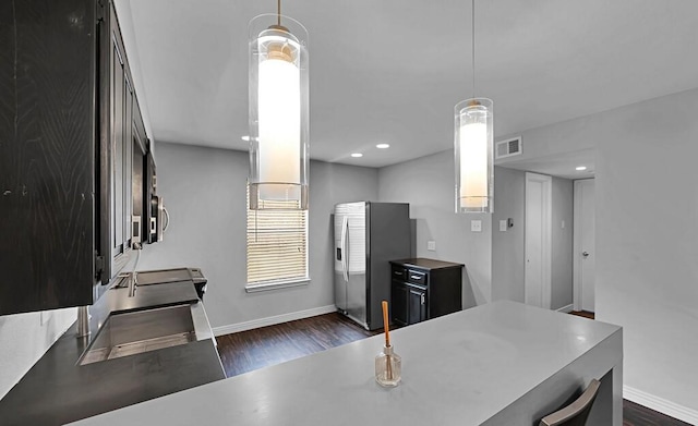 kitchen featuring visible vents, baseboards, dark wood-style flooring, and stainless steel fridge with ice dispenser