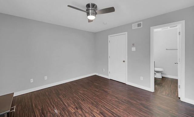 unfurnished bedroom featuring wood finished floors, visible vents, baseboards, ceiling fan, and ensuite bathroom