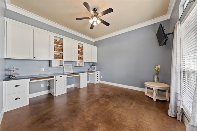 kitchen with white cabinets, built in desk, ceiling fan, and crown molding