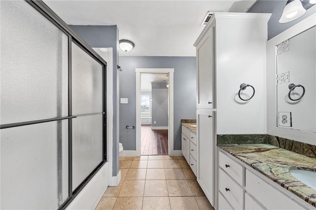 full bathroom featuring toilet, vanity, tile patterned floors, and combined bath / shower with glass door