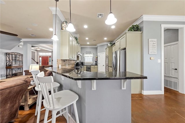 kitchen featuring hanging light fixtures, stainless steel fridge, tasteful backsplash, a kitchen bar, and kitchen peninsula