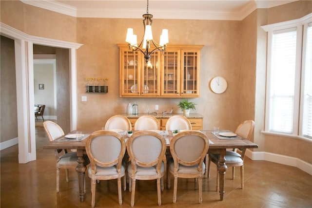 dining area featuring crown molding, baseboards, and an inviting chandelier