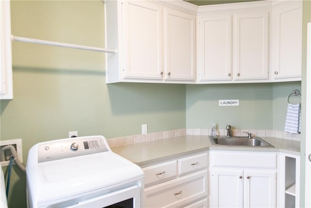 clothes washing area with washer / clothes dryer, a sink, and cabinet space