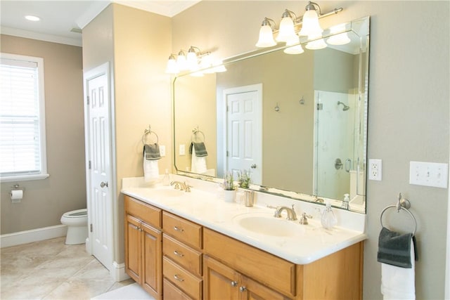 bathroom featuring toilet, a sink, a shower stall, double vanity, and crown molding