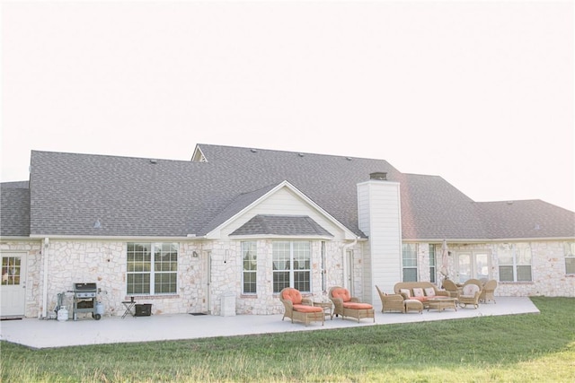 rear view of house featuring a shingled roof, a lawn, a chimney, an outdoor hangout area, and a patio area