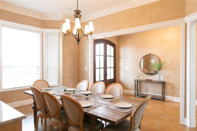 dining space with french doors, an inviting chandelier, ornamental molding, light tile patterned flooring, and baseboards