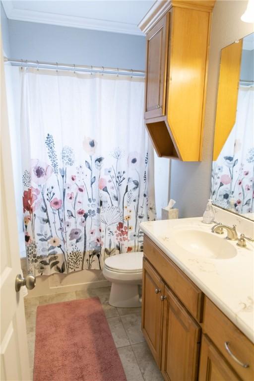 bathroom with ornamental molding, vanity, toilet, and tile patterned floors