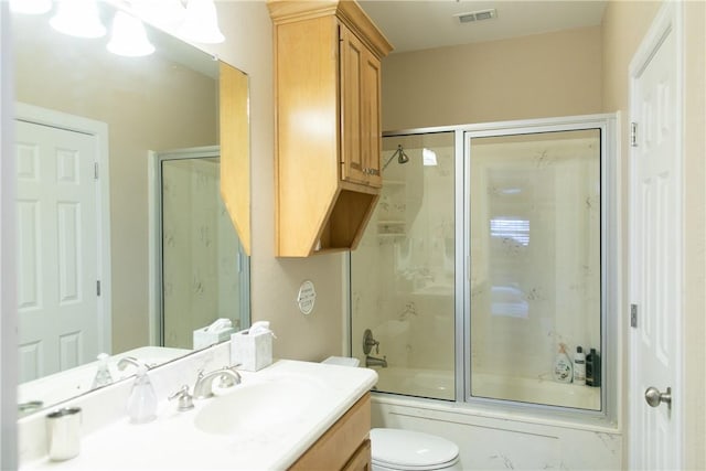 bathroom with toilet, combined bath / shower with glass door, vanity, and visible vents