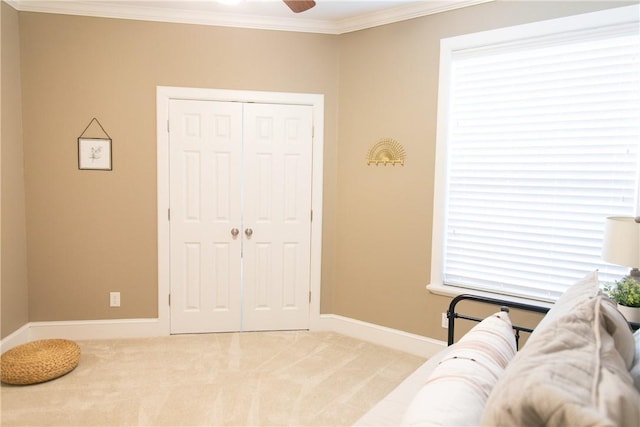 living area with light carpet, baseboards, a ceiling fan, and crown molding