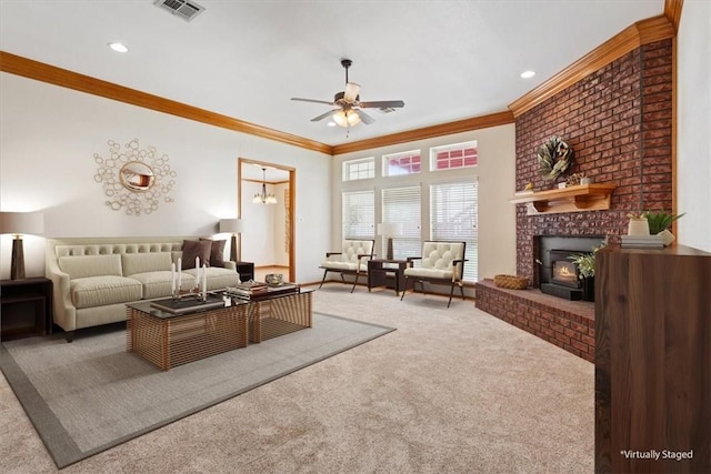 living room with ceiling fan with notable chandelier, carpet floors, a wood stove, and ornamental molding