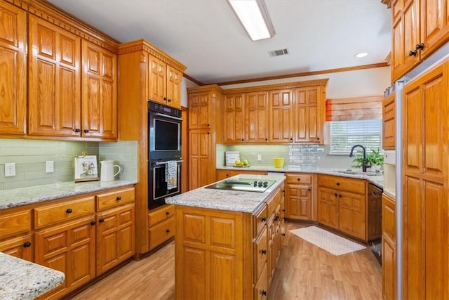 kitchen with a center island, backsplash, black appliances, light hardwood / wood-style flooring, and ornamental molding