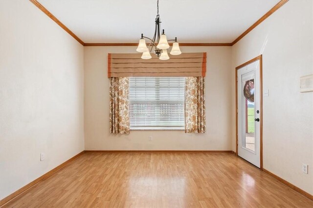 spare room featuring ornamental molding, light hardwood / wood-style floors, and a notable chandelier