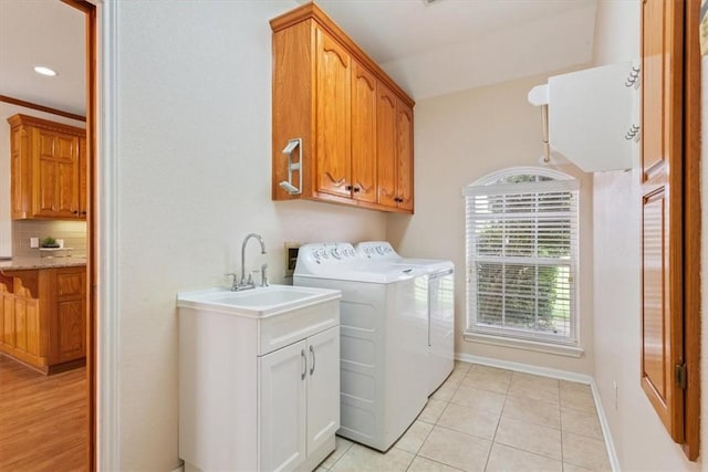 laundry room featuring light tile patterned flooring, cabinets, and washing machine and clothes dryer