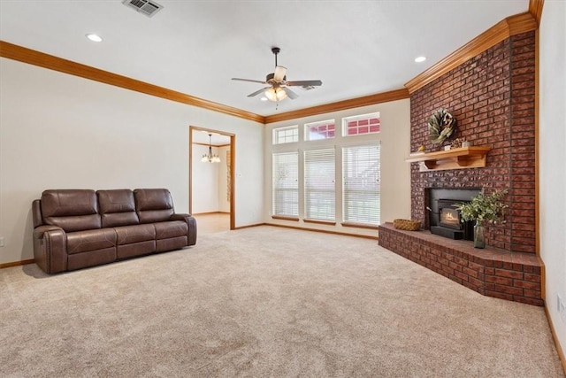 carpeted living room featuring ceiling fan with notable chandelier, a wood stove, and ornamental molding