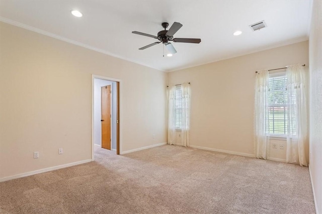 unfurnished room featuring ceiling fan, light colored carpet, and ornamental molding